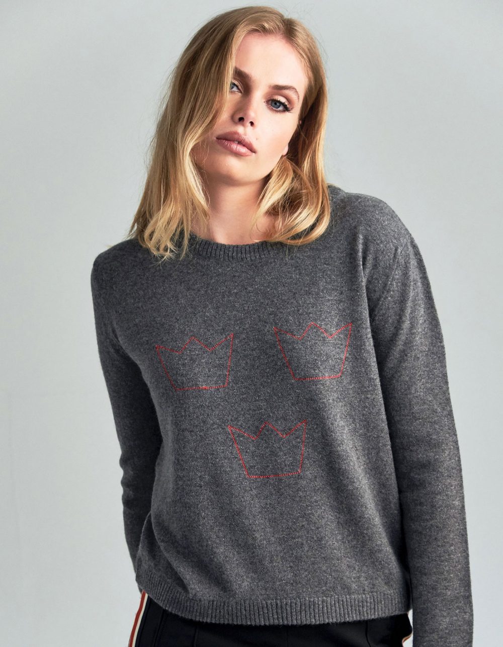Studio image of a woman in cashmere knitwear, a malin darlin Three Crowns cashmere jumper.