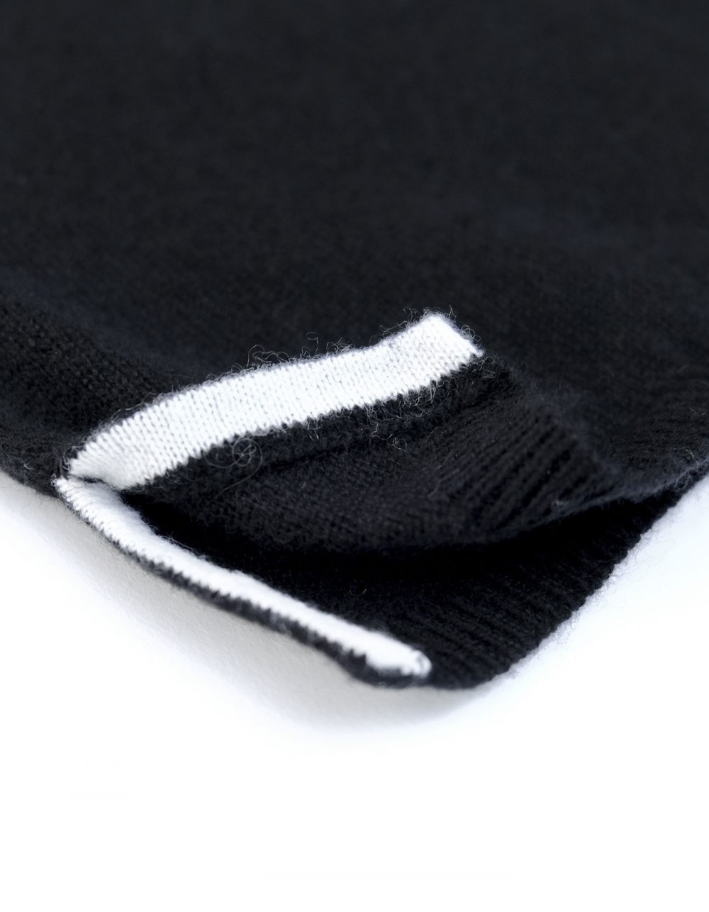 Hem close up of the malin darlin Darlin black cashmere jumper showing contrast and knit detail.