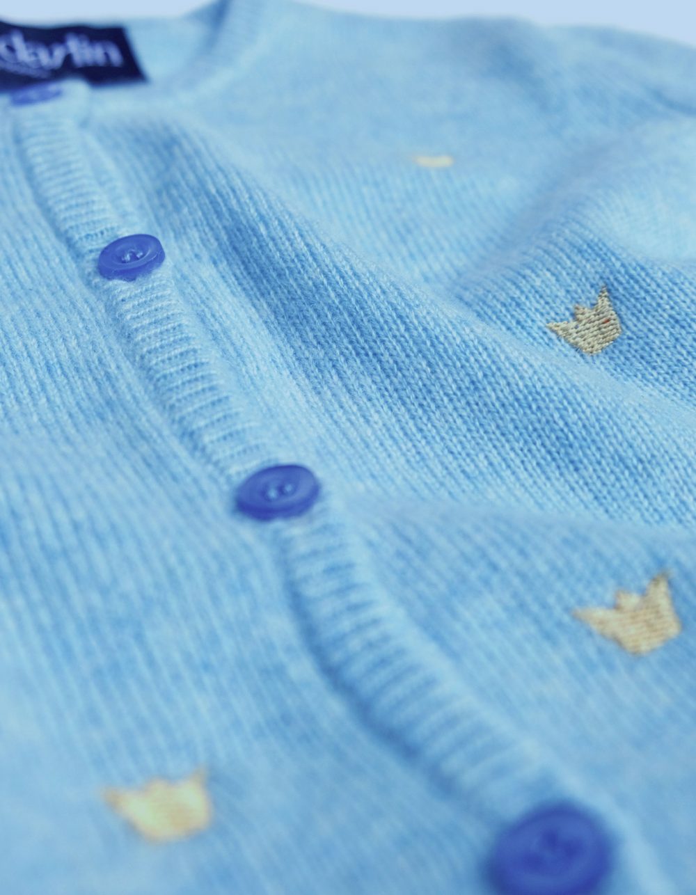 Close up of the malin darlin designer baby cardigan showing button and cashmere knit detail.