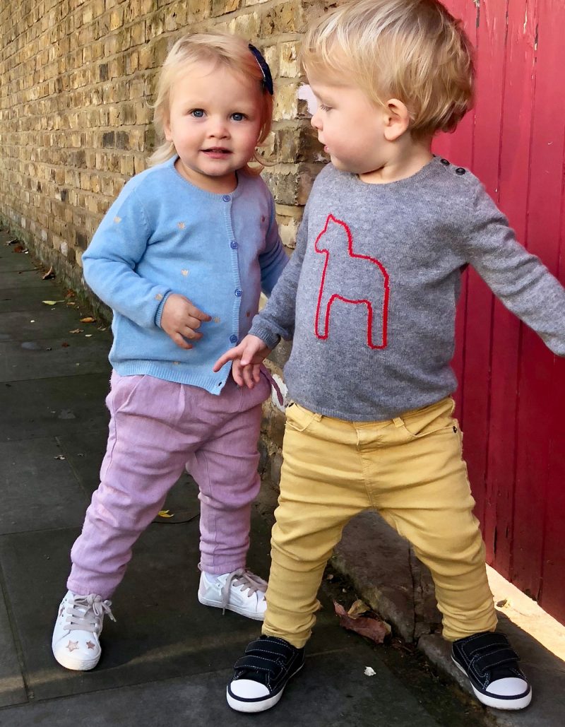Two toddlers playing, both dressed in malin darlin kids cashmere knitwear.