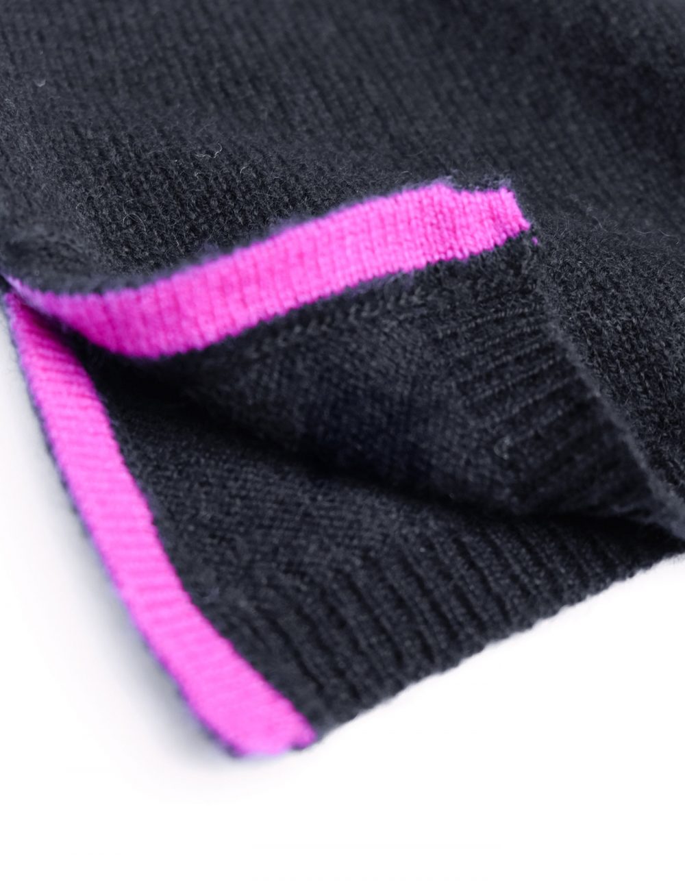 Zoomed detail of cashmere knitwear showing intarsia knit black cashmere with pink highlights.