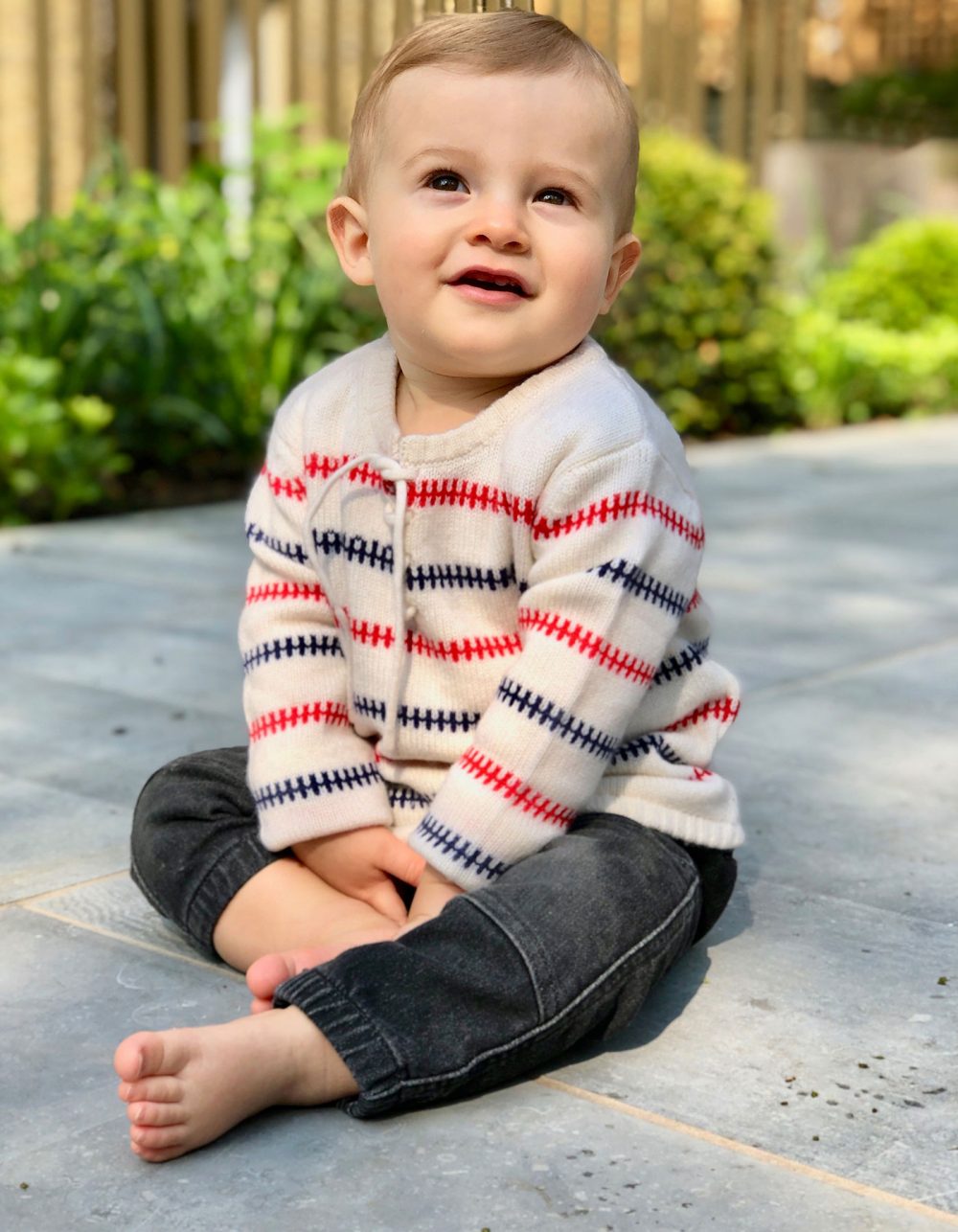 A smiling child in the Baby Fisher kids cashmere jumper, part of the malin darlin childrens cashmere collection.