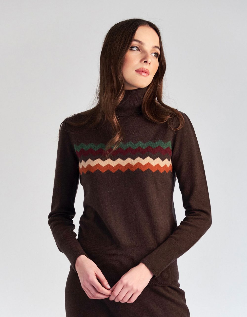 Woman wearing a designer cashmere jumper decorated with zigzag patterns.