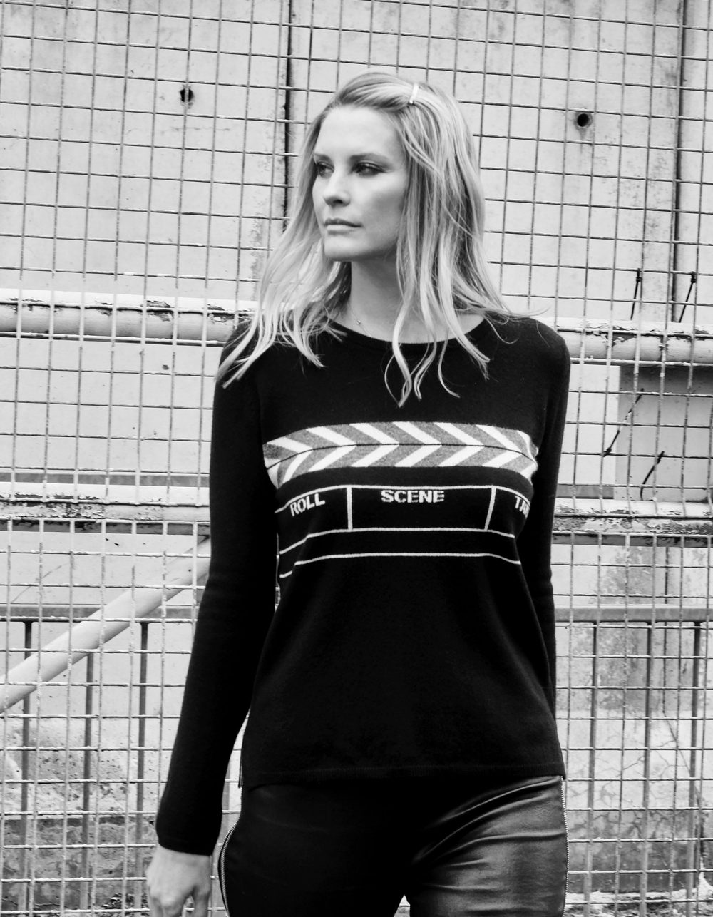 Image of a model wearing designer knitwear, a malin darlin Scene womens cashmere jumper, in an urban setting.
