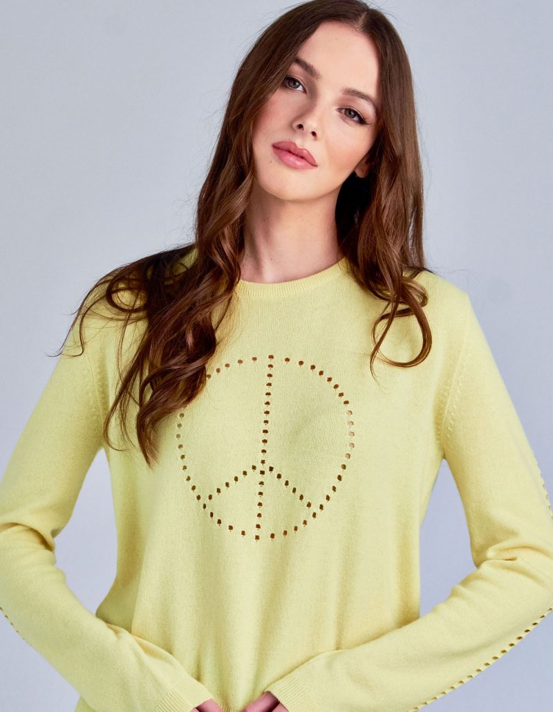A studio shot of a model in designer cashmere knitwear, the malin darlin Peace cashmere jumper.